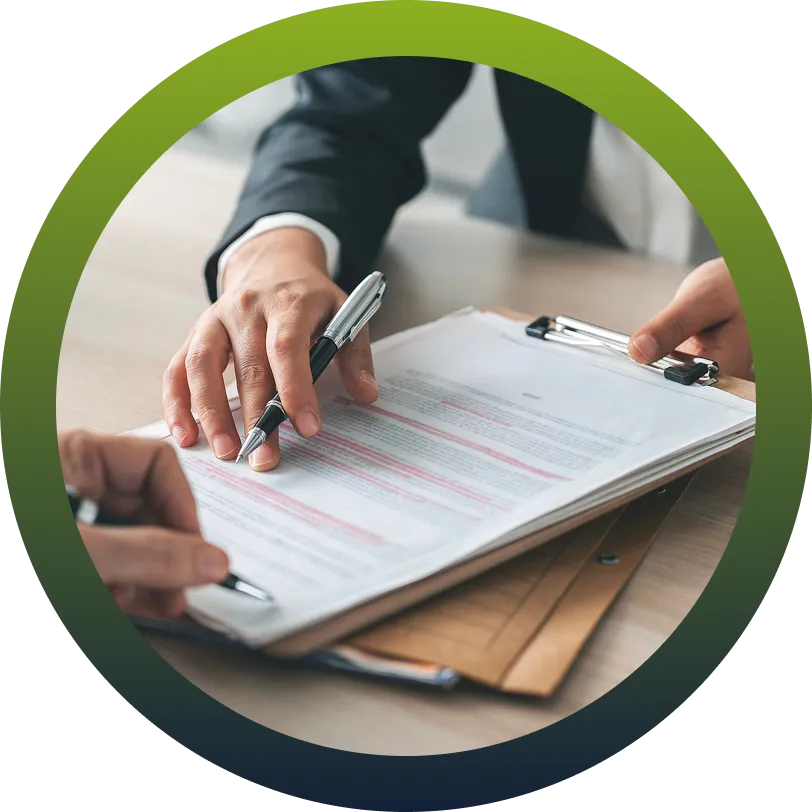 Two people at a desk reviewing and marking up printed plan documents
